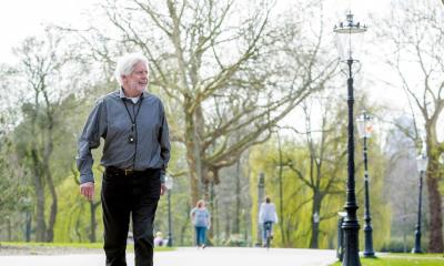 Man loopt in een park met dwaaldetectie alarm