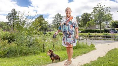 Vrouw laat hond uit met mobiele alarmering.